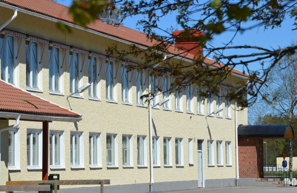 Bild på delar av Timmele skola som är en ljusgul stenbyggnad i två våningar