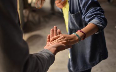 Bild på två händer som håller varandras händer