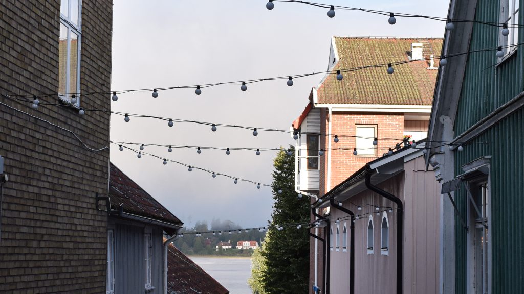 Linspänd belysning mellan hus i en gränd.