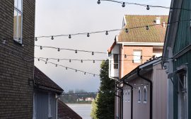 Linspänd belysning mellan hus i en gränd.